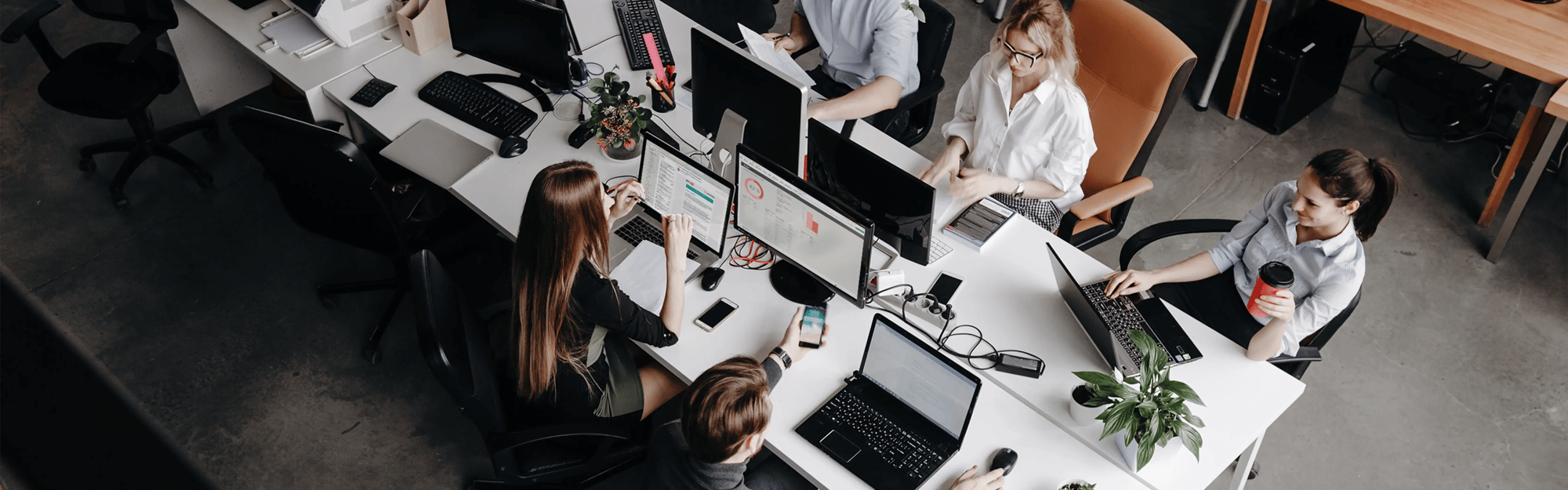 Ein Team arbeitet konzentriert in einer Shared-Desk-Umgebung