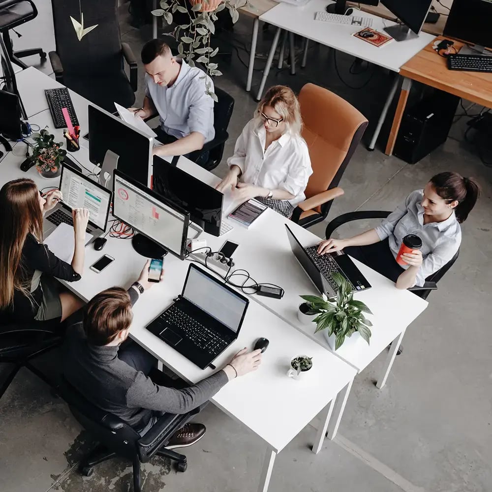 Eine kleine Gruppe von Mitarbeitenden arbeitet an ihren Computern mit Managed Service