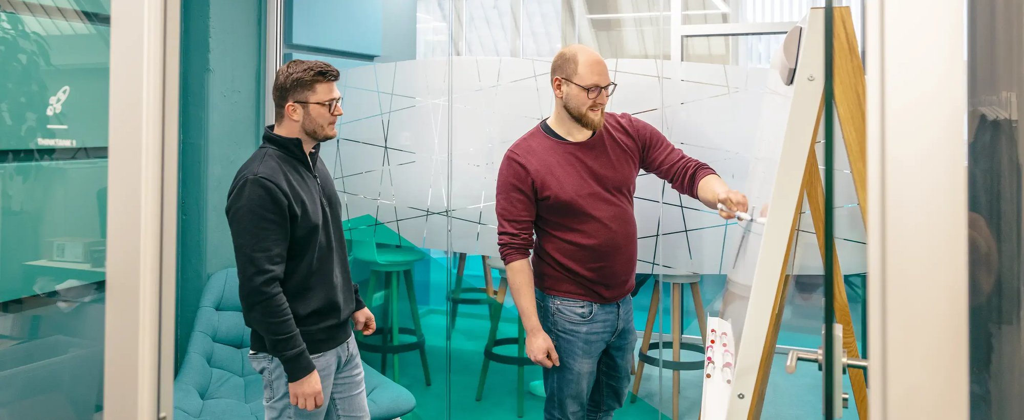 Zwei Herren diskutieren an einem Whiteboard die Vorgehensweise beim Backup