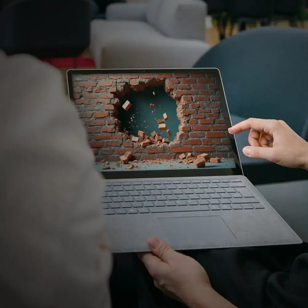 Ein Laptop mit einer zerstörten Wand als Symbolbild für eine Firewall, die ein Update braucht