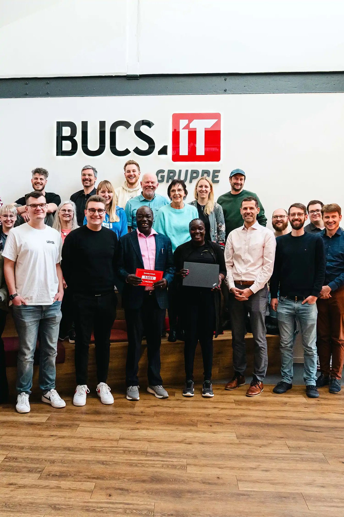 Ein Gruppenfoto mit Ehepaar Ochieng im Foyer der BUCS IT Gruppe