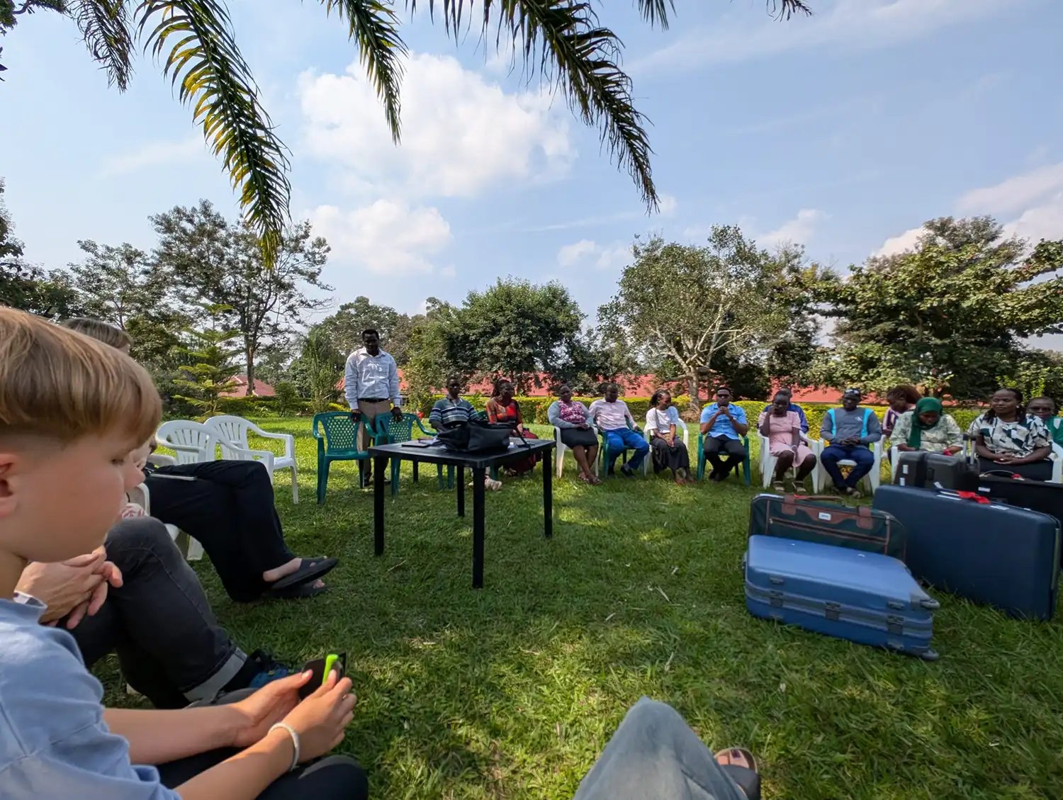 Eine Gruppe Menschen sitzt auf einer Wiese