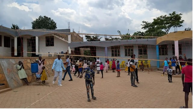 Eine Schule in Uganda mit Kindern auf dem Schulhof