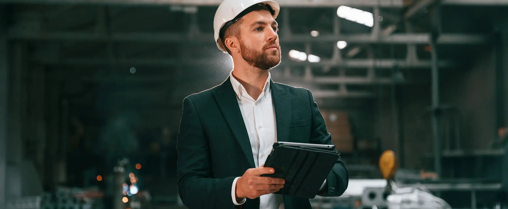 Ein IT-Manager mit einem Tablet in einer Produktionshalle während eines IT-Carve-outs