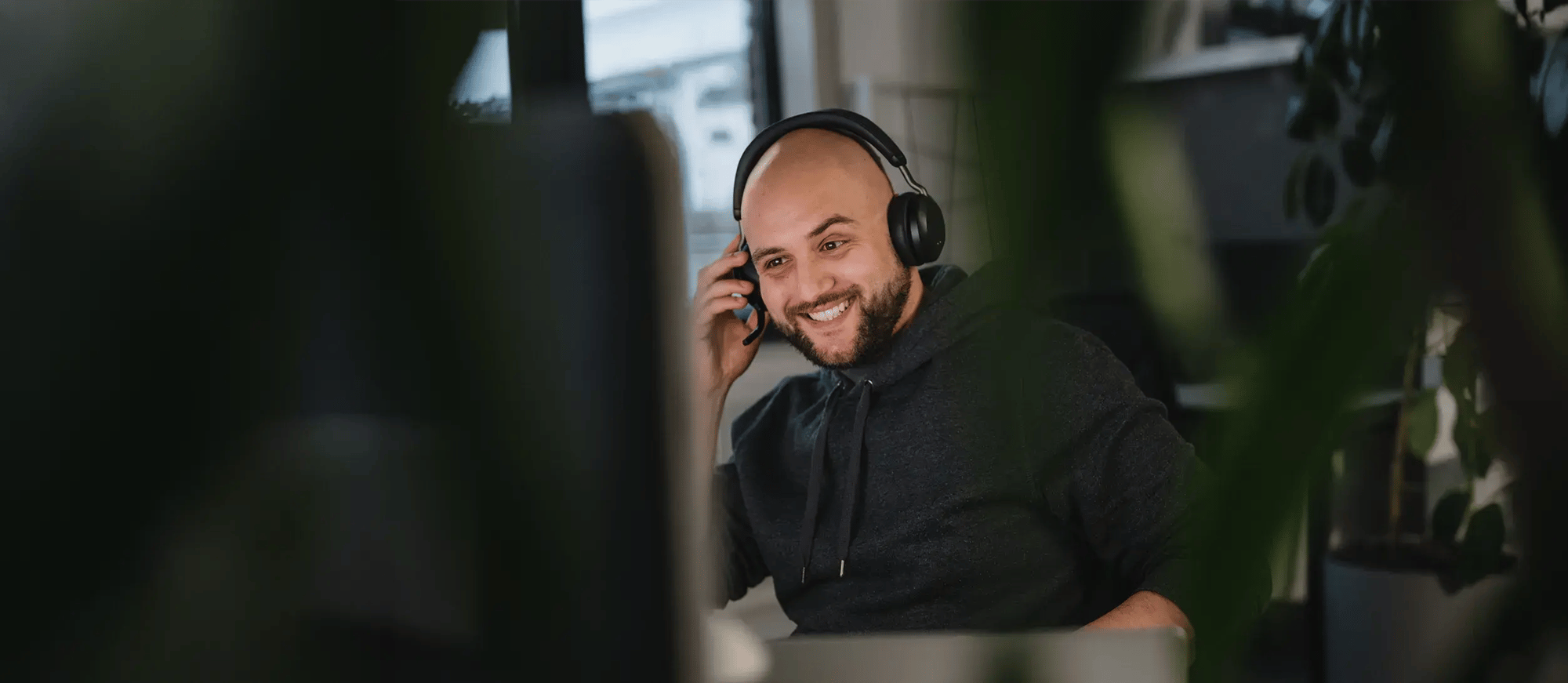 Zufriedener IT-Verantwortlicher mit Headset im Büro