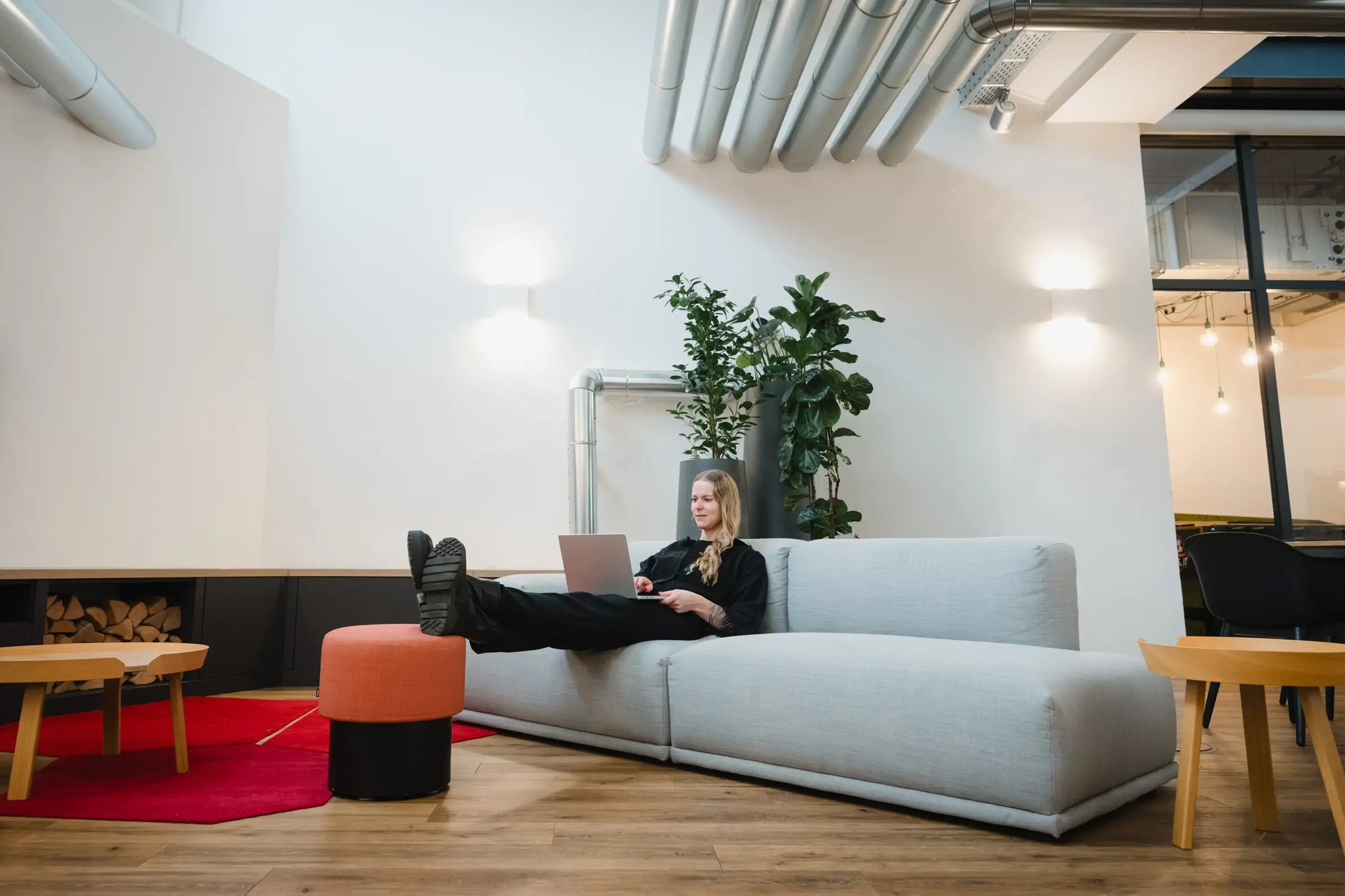 Eine Mitarbeiterin sitzt lässig auf einer Couch