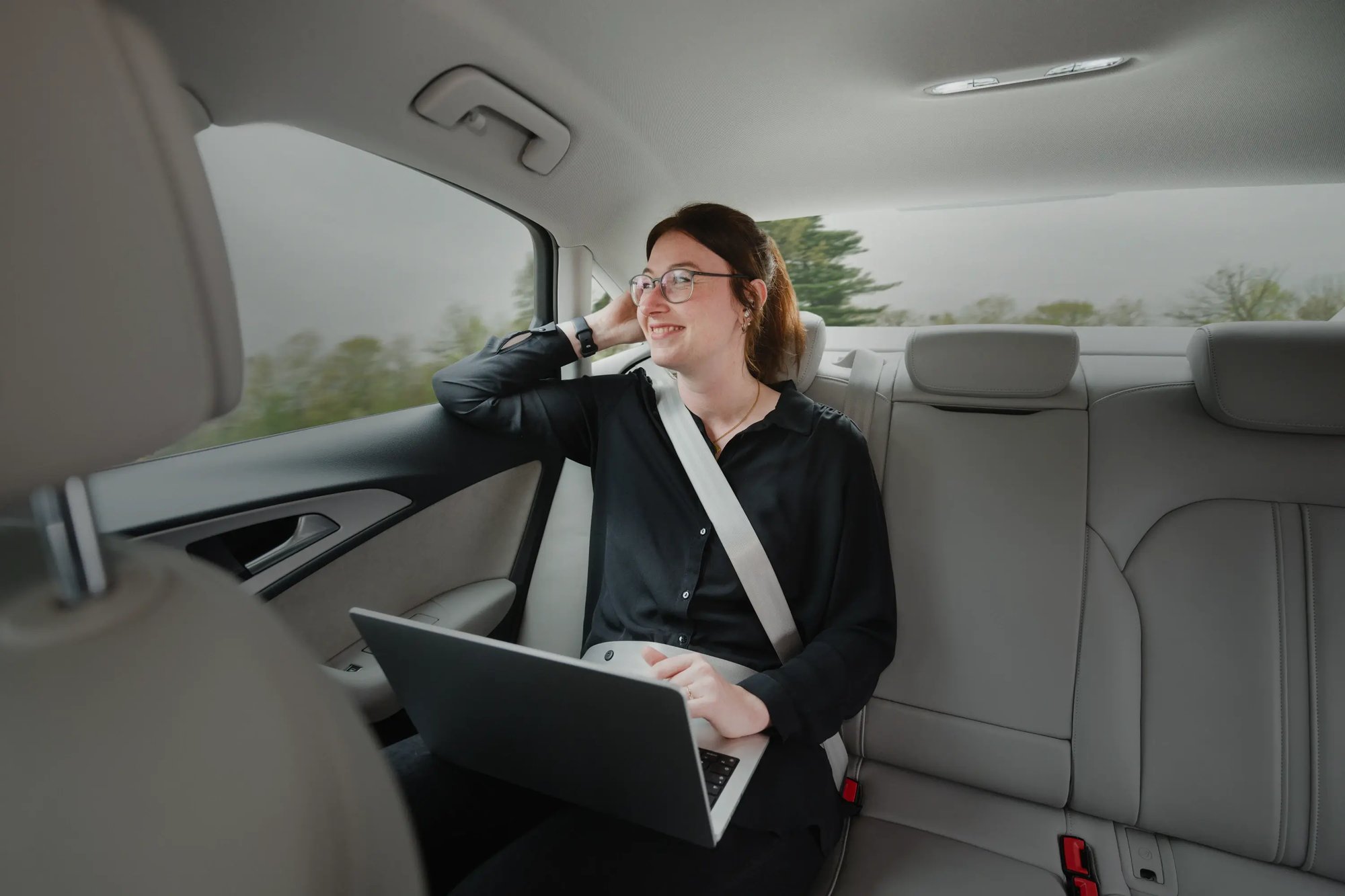 Eine Frau sitzt auf der Rückbank eines Autos