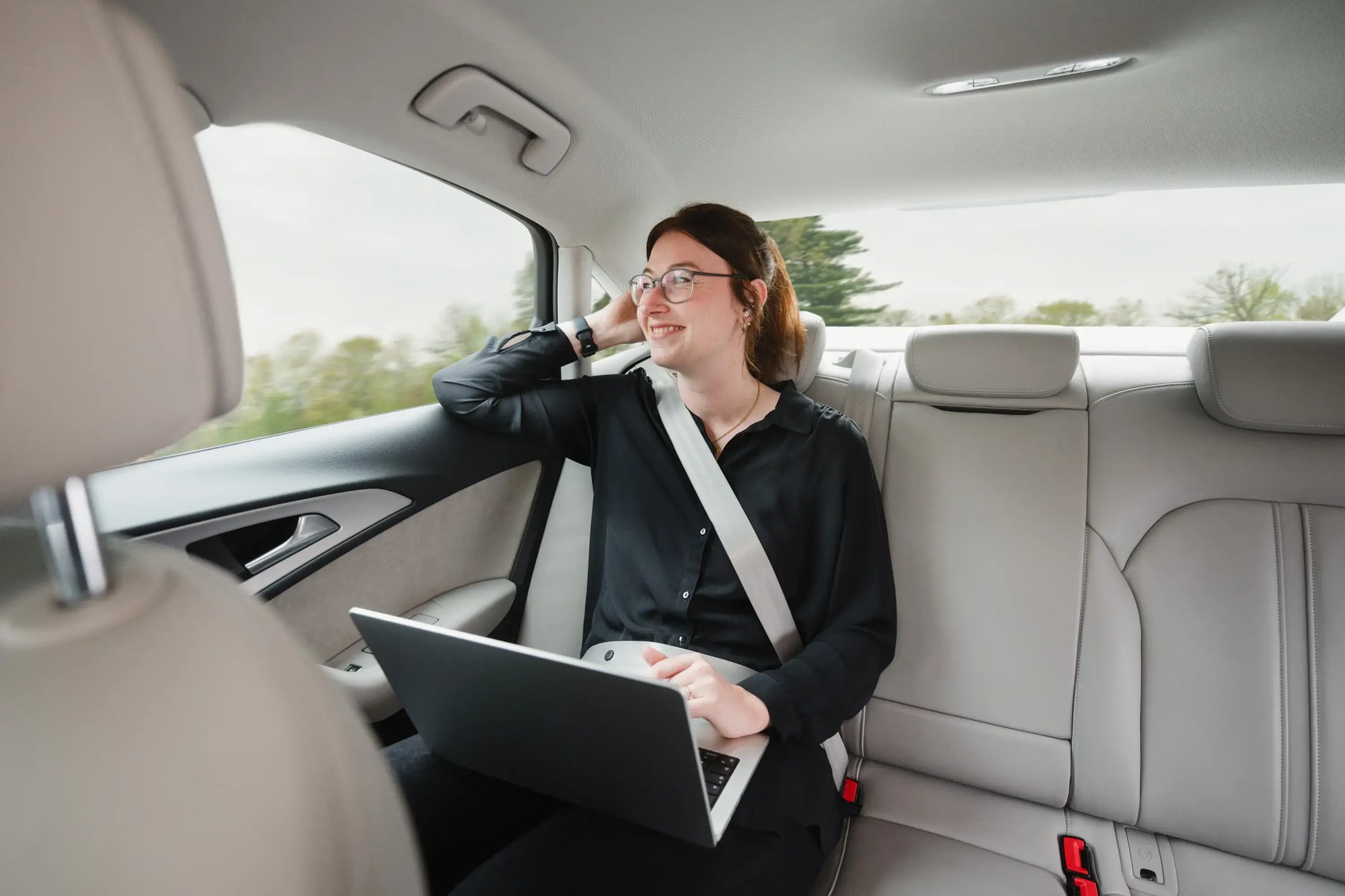 IT-Technikerin sitzt in einem Auto und telefoniert zum Thema Digital Workplace