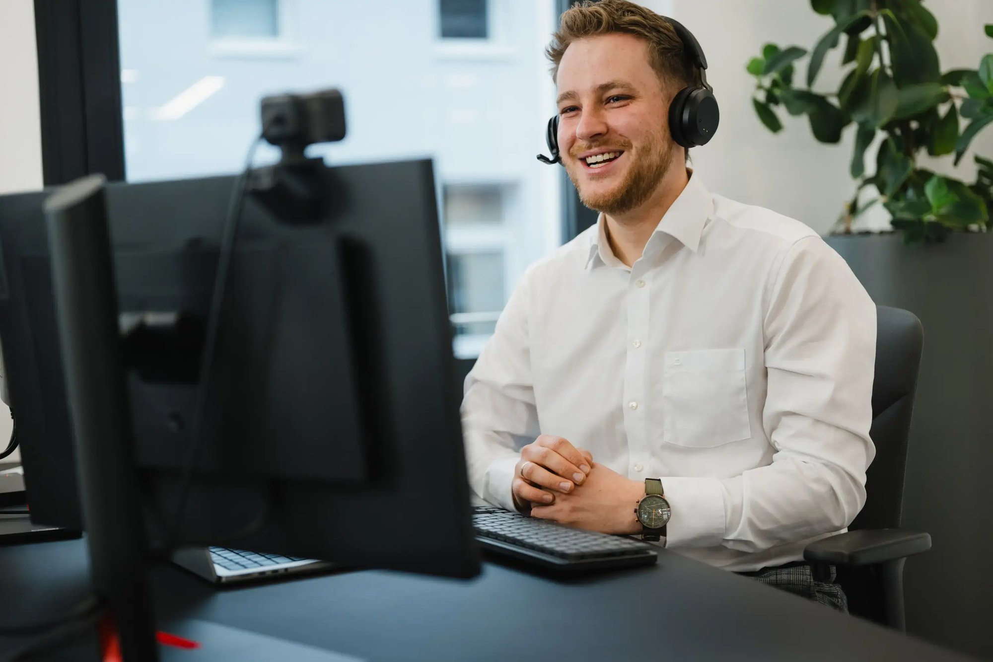 Ein IT-Berater im Gespräch via Headset und Webcam
