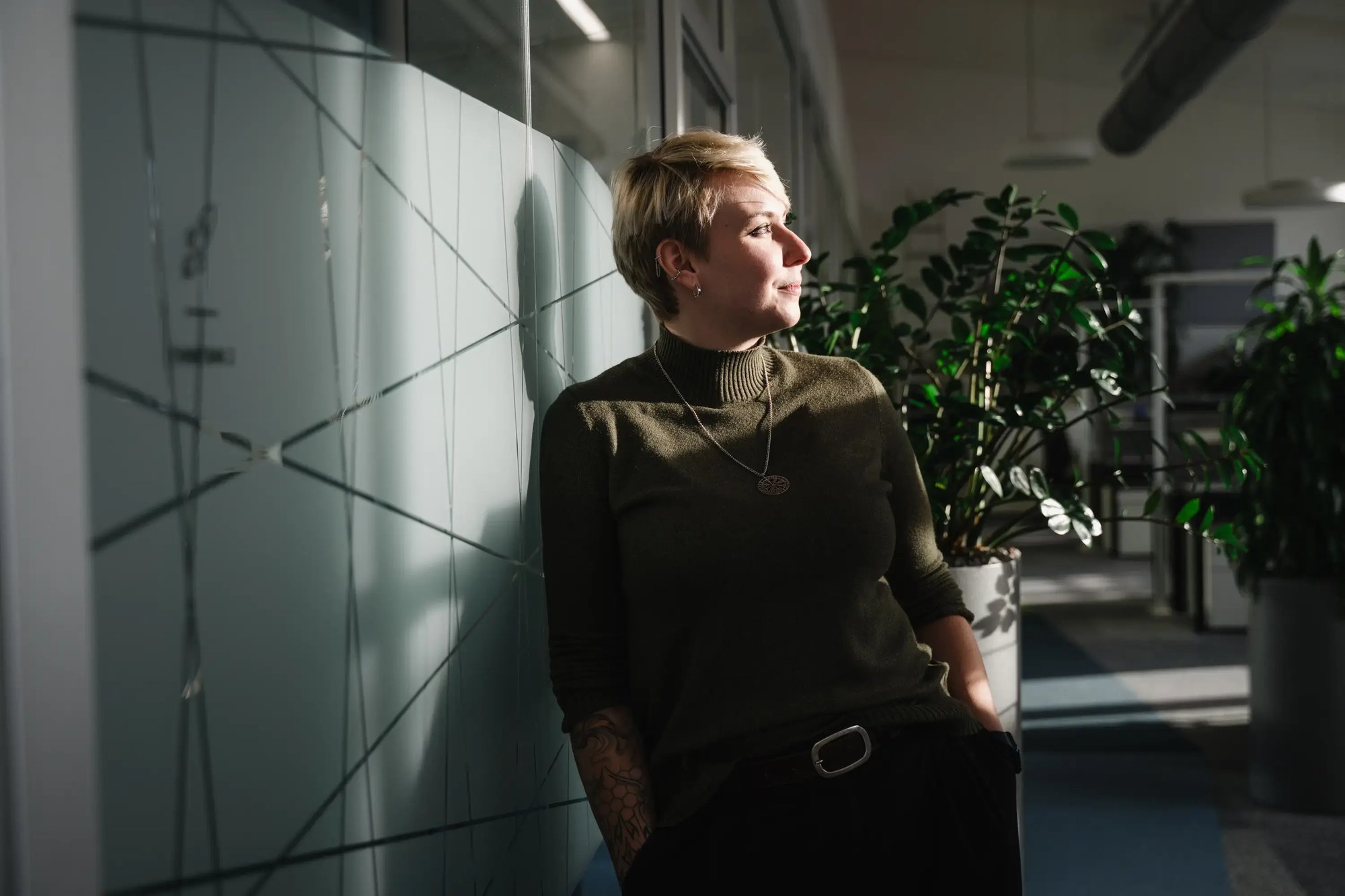 IT-Expertin lehnt an einer Glaswand