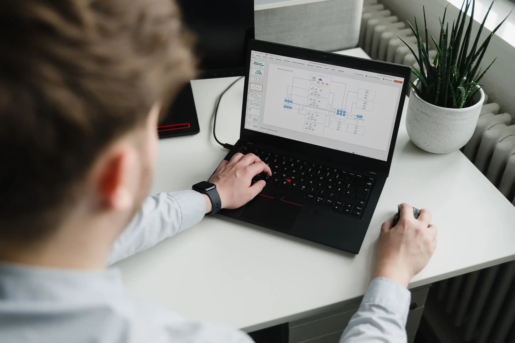 Ein Mann sitzt an einem Laptop und plant eine IT-Infrastruktur
