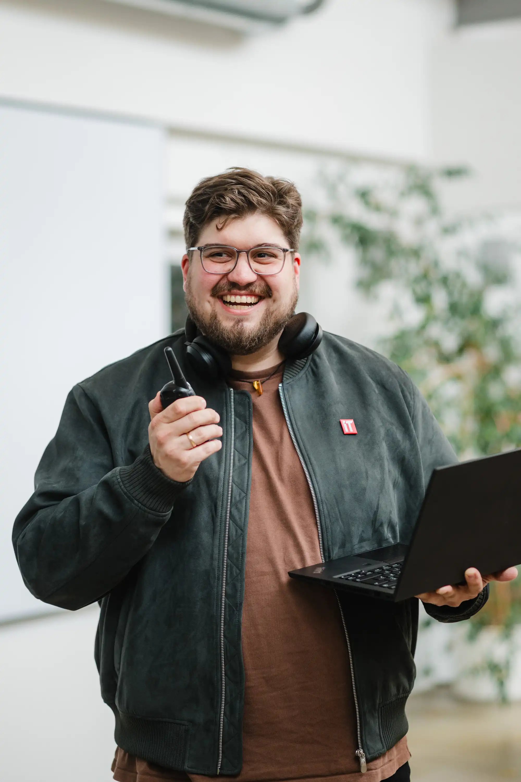 Ein IT-Experte lacht beim Gespräch mit Walkie Talkie