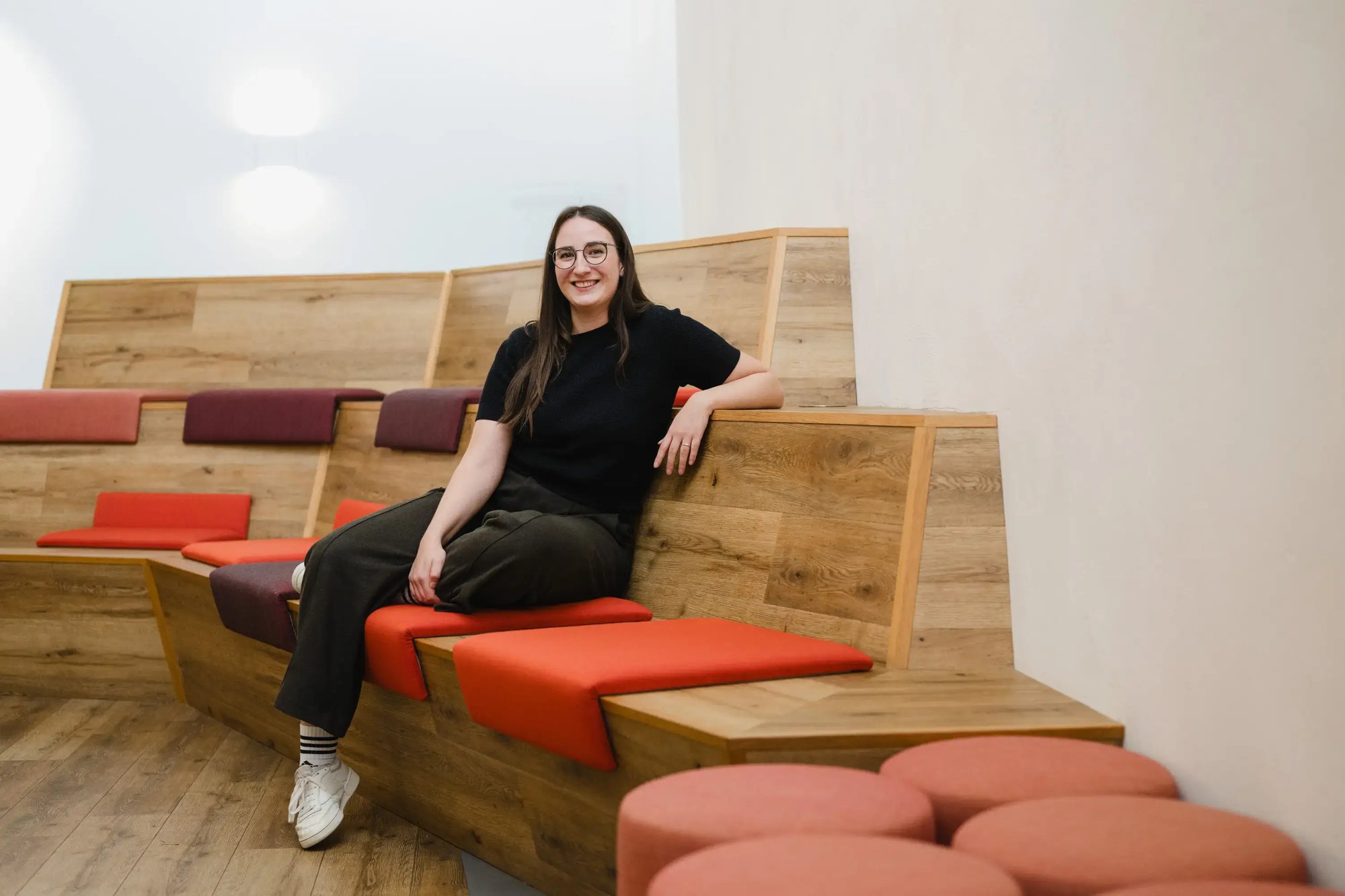 Eine Frau sitzt auf einer Bank im Foyer