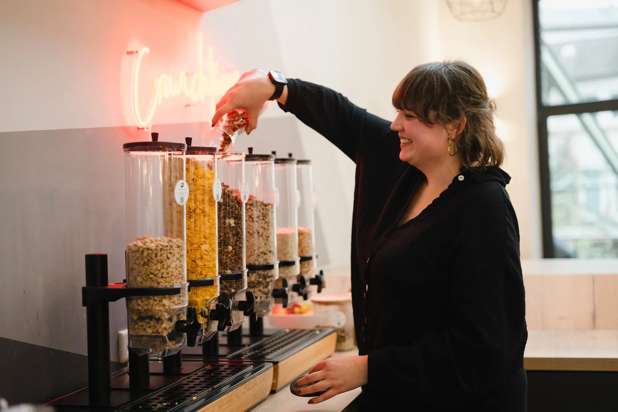 Eine Mitarbeiterin kümmert sich um die Müslibar