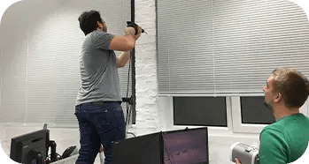 Ein Mann bohrt ein Loch und ein anderer guckt zu