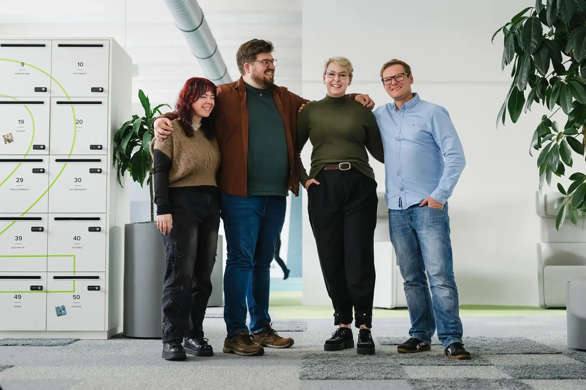 IT-Team posiert neben Schließfächern