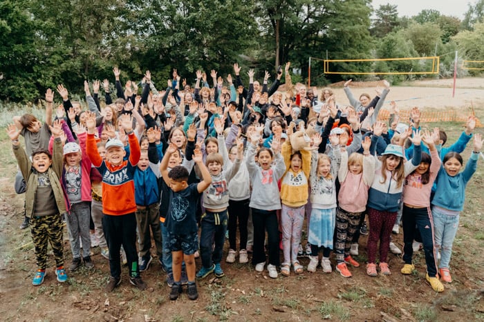 Eine Gruppe Kinder freut sich und reckt die Arme in die Luft
